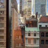 Photo of my reflection on a glass in front of Manhattan buildings