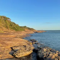 Photo of the sunset over rocks in the ocean